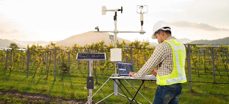 Technician checking data from an installed weather station