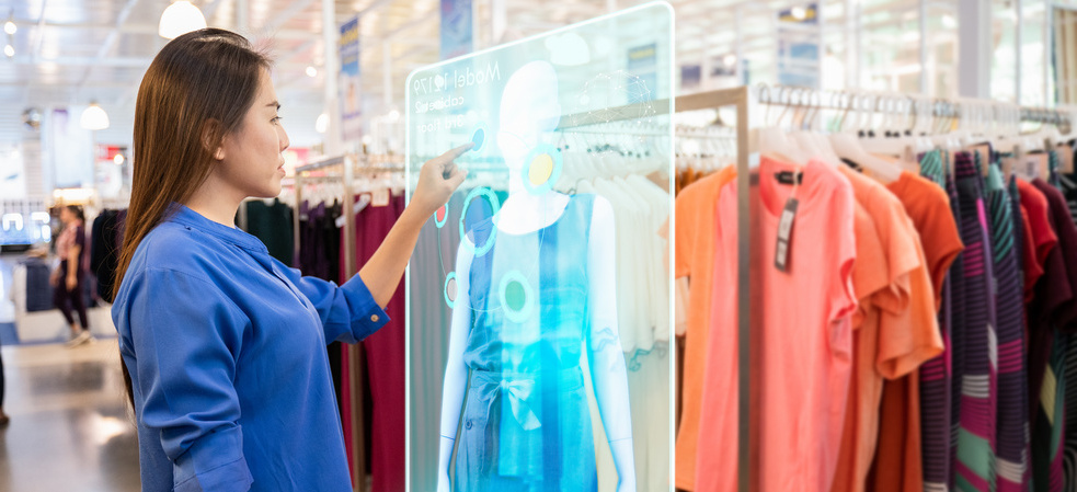 woman shopping in a store using a holographic display to choose her clothes