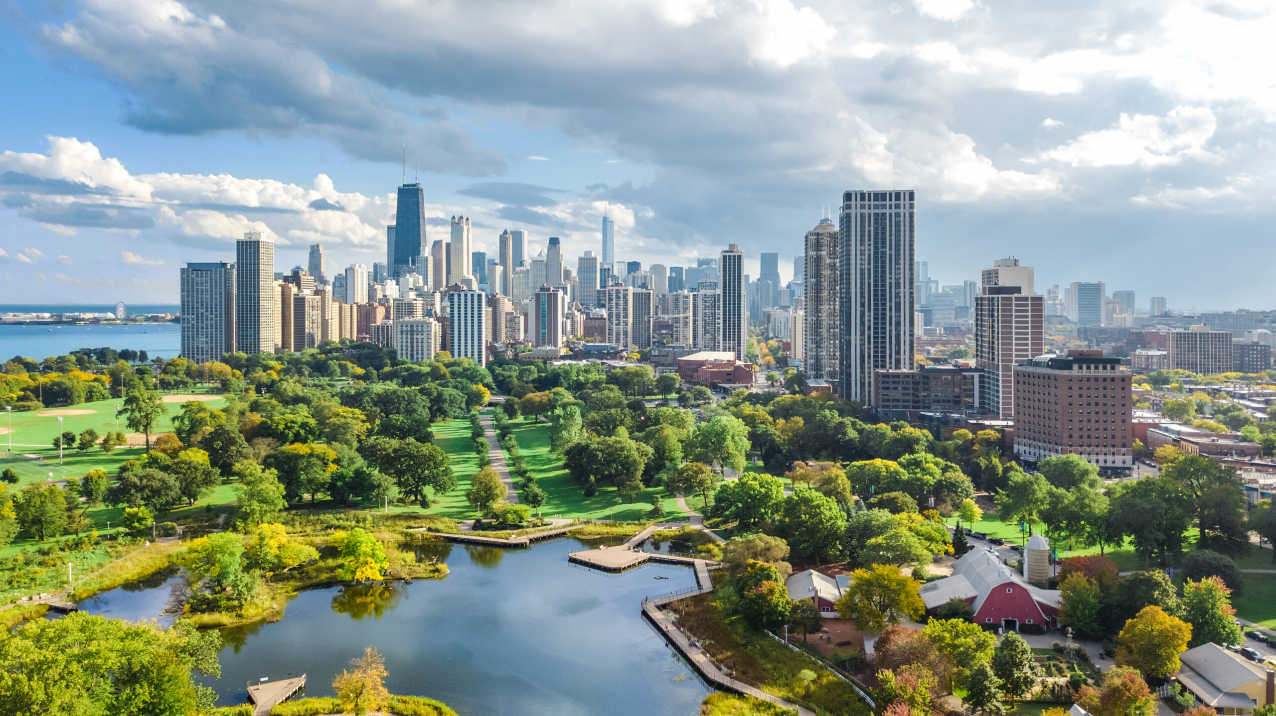 Aerial view of city skyline with skyscrapers, green park, and water features.