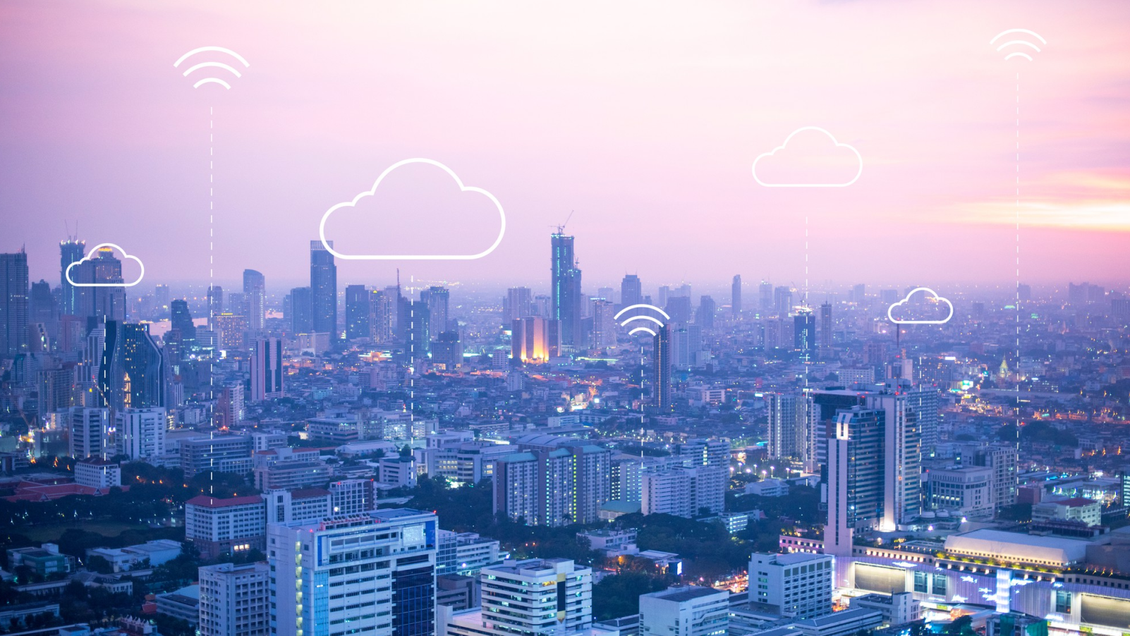 Smart city with cloud computing and wireless network icons over skyline at sunset.