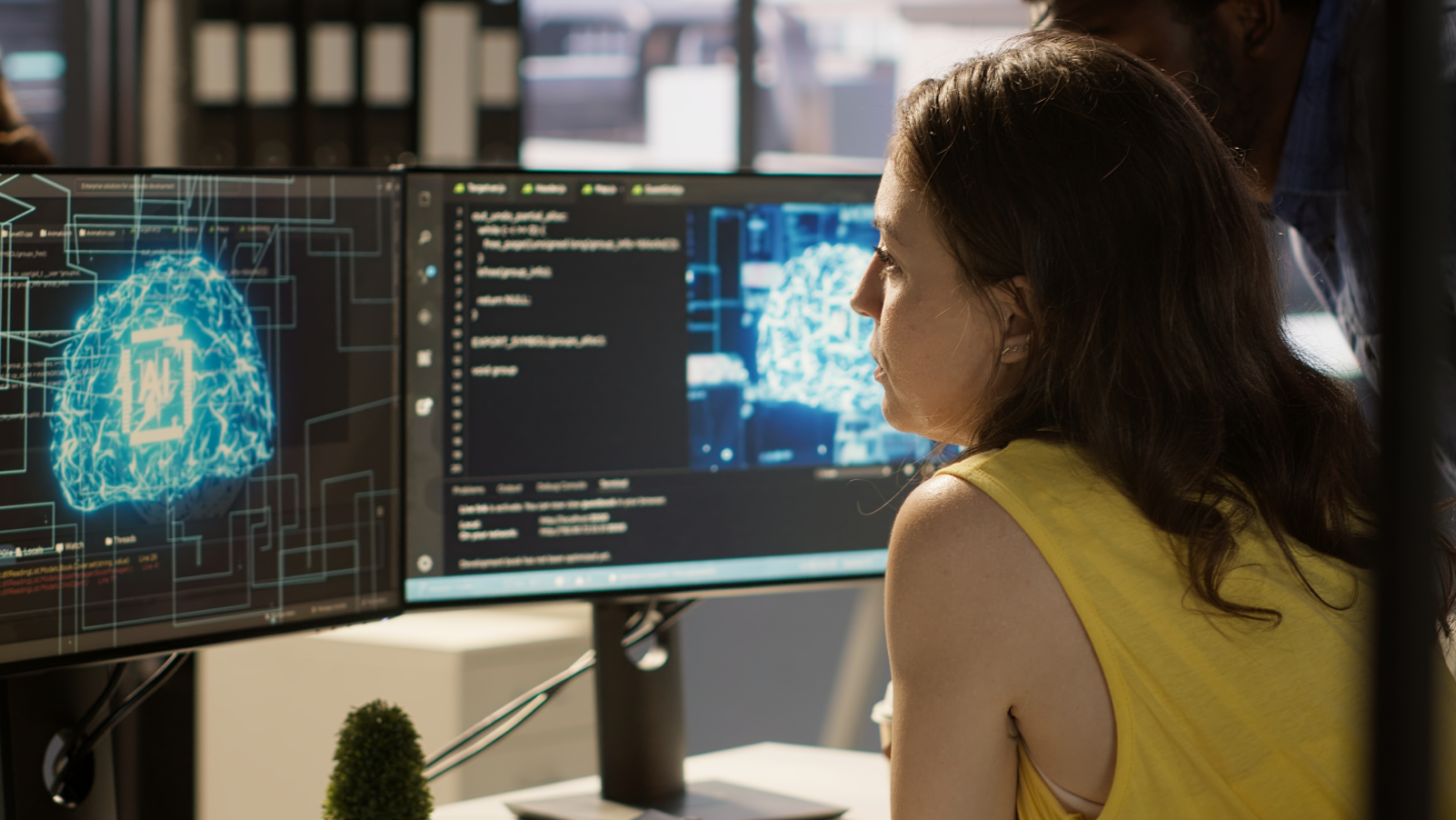 Workspace setup featuring dual monitors displaying brain imagery and code.