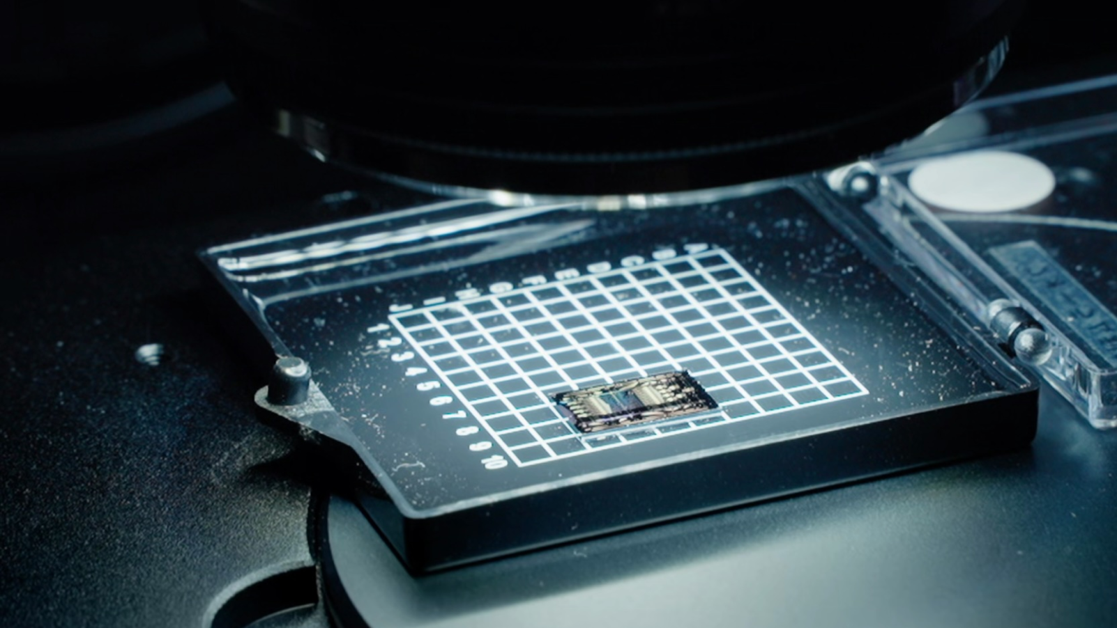 Close-up of a microchip on a grid-patterned surface.